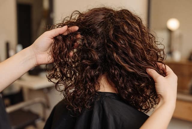 Lockige Haare werden im Salon in Form gebracht